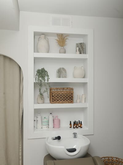 The wash station at Vella with treatment products on built-in shelving